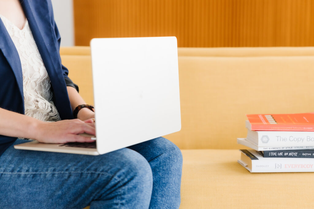 A woman writing on a laptop, representing how to increase your email open rate with an engaging subject line