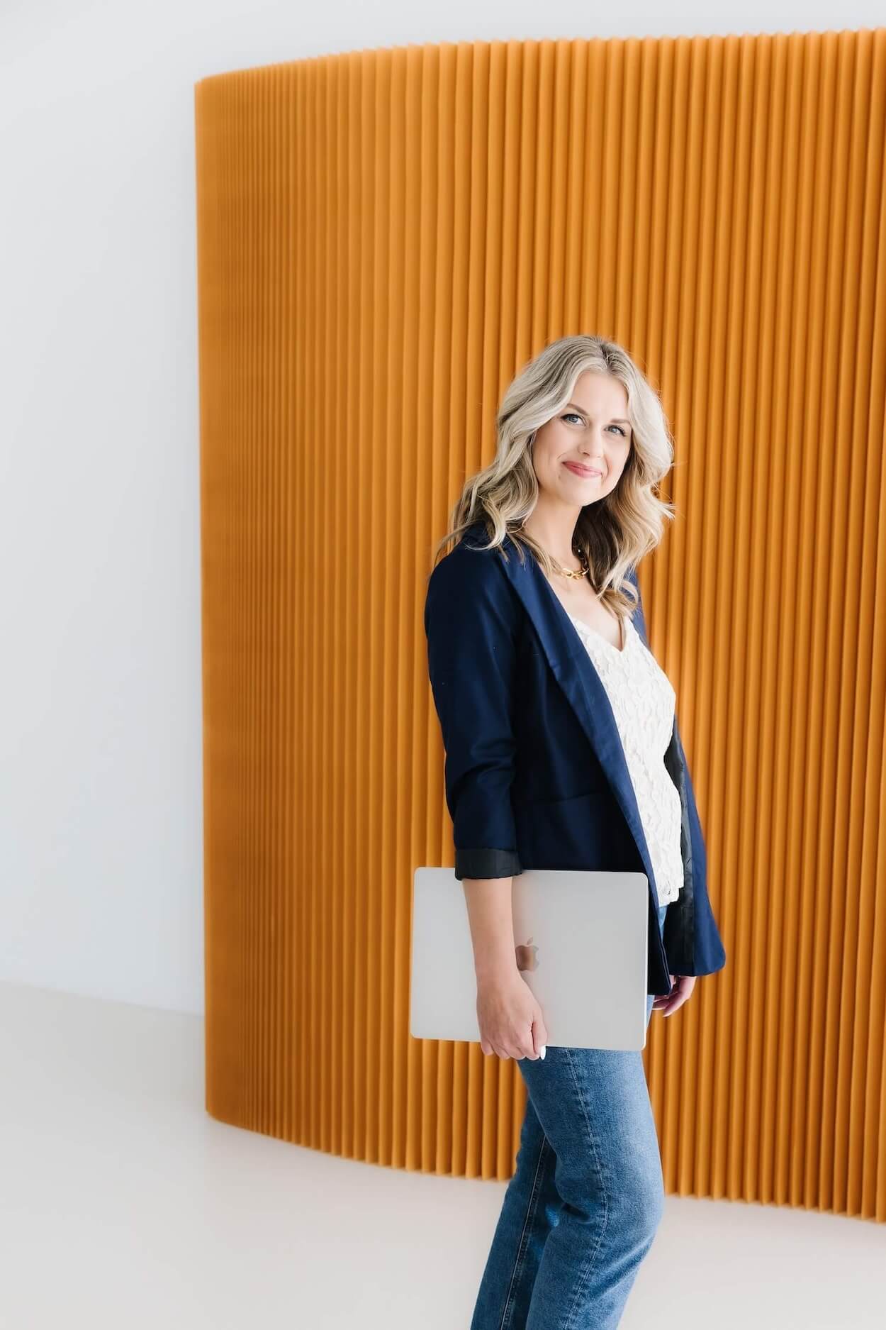 Sarah Klongerbo holding a laptop, illustrating her simple brand messaging strategy for creative businesses