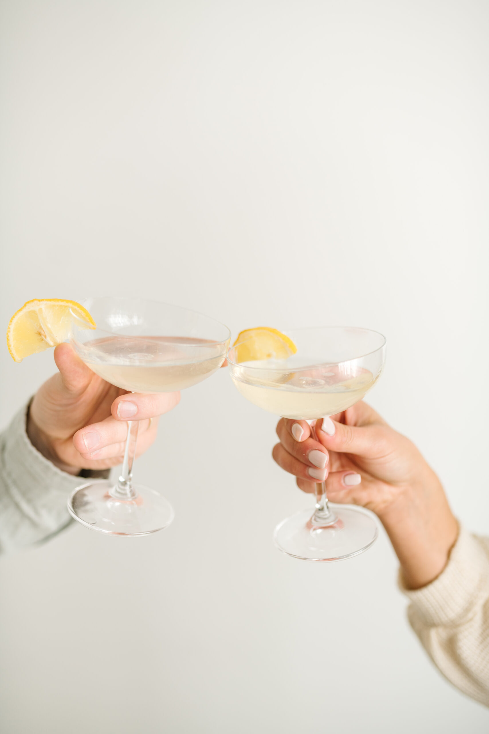 Two hands holding coupe glasses, cheers-ing to their 2026 word of the year